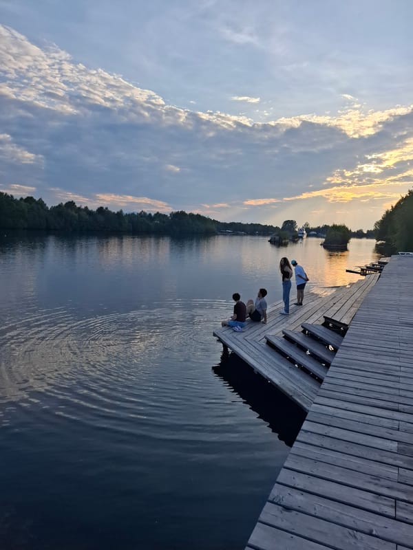 Sunset at a lakeside dock near Vydrino's mountain shoreline