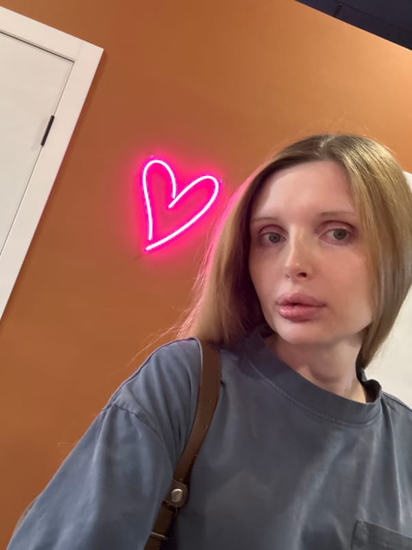 Selfie session around a pink neon heart sign