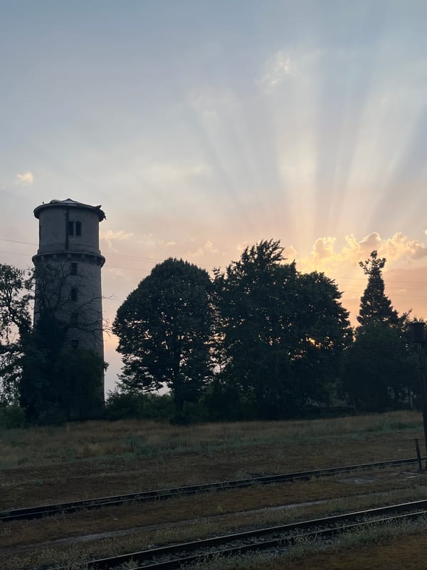 Bansko at sunset: stone water tower and mountain-backed streets