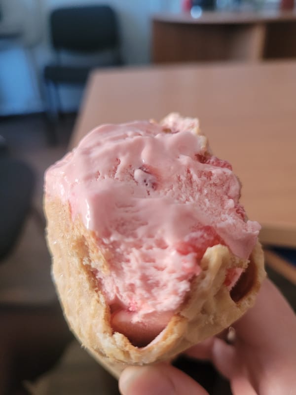 Person enjoys melting pink ice cream in Izhevsk