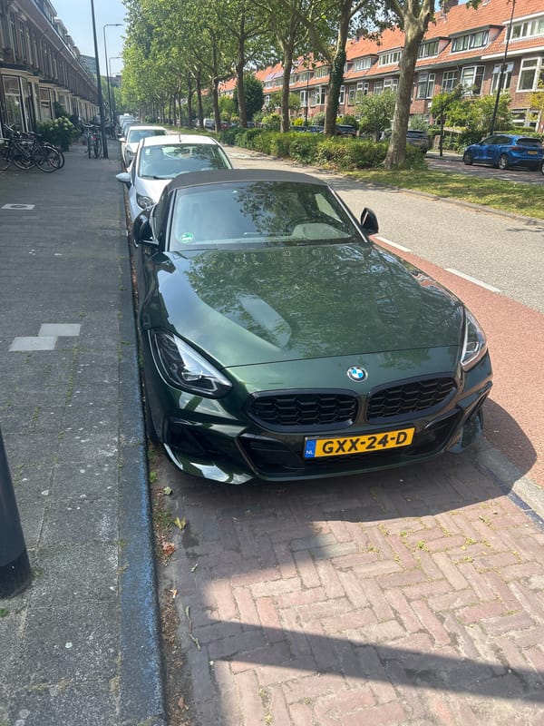 Parked BMW and historic orphan statue in Leiden streets