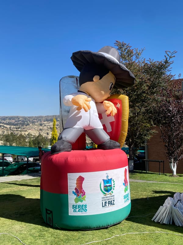 College students gather around inflatable mascot in Achocalla