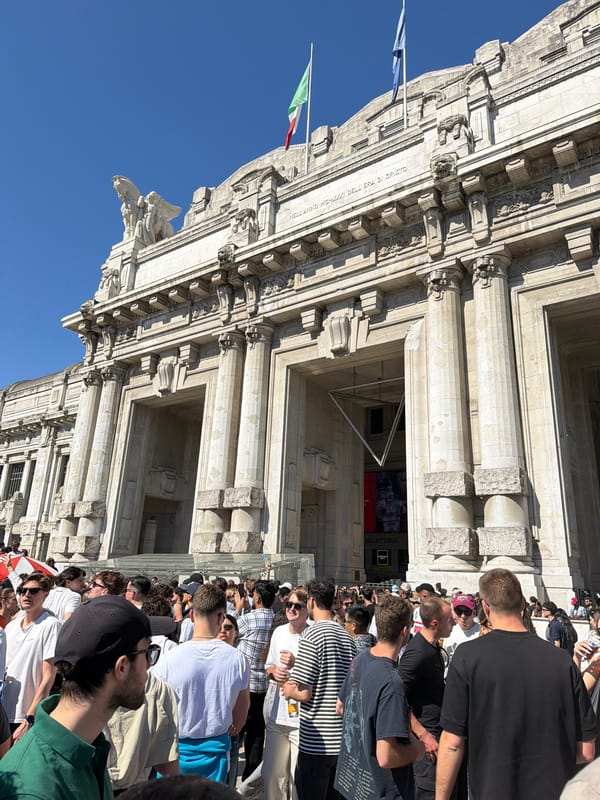 Crowds gather at Milan Central Station's neo-classical facade