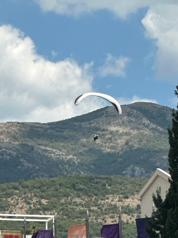 Paragliders soar over Montenegro's Adriatic coastline