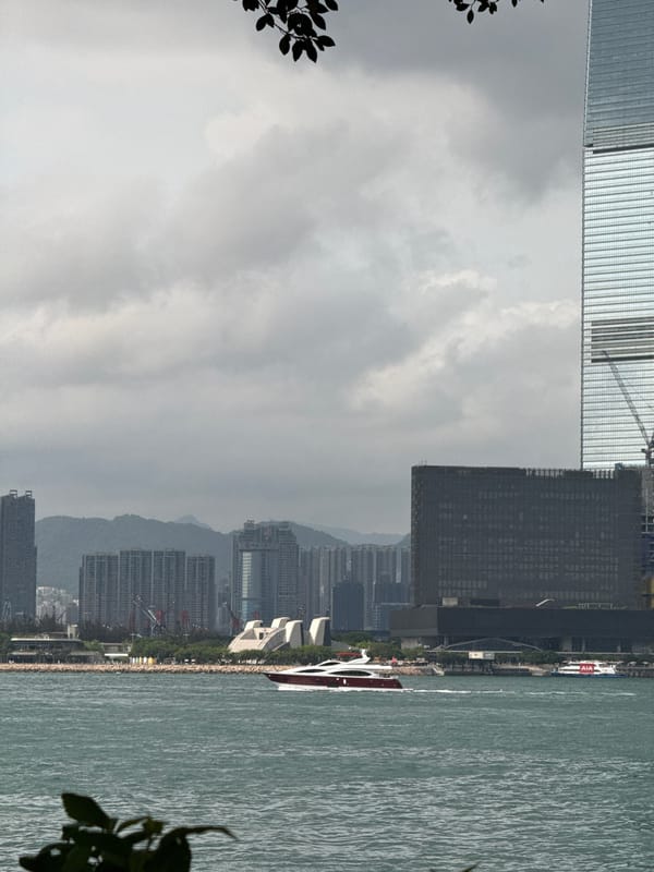 Two cars parked under overpass in Hong Kong waterfront area