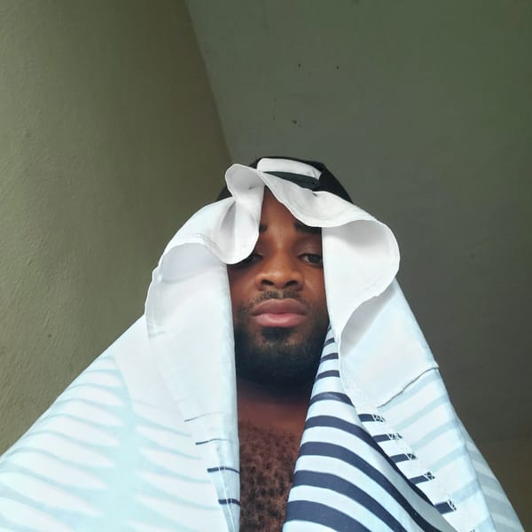 Man photographed under striped sheet in Obosi, Nigeria