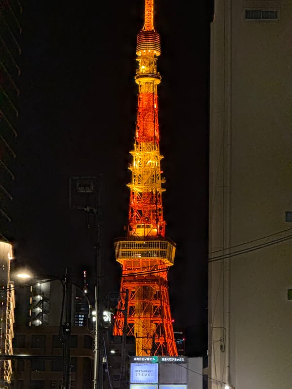 Tokyo Tower glows orange-yellow in nighttime Minato district photo