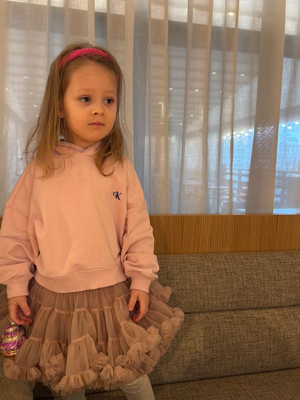 Girl in pink outfit rests on couch in Moscow