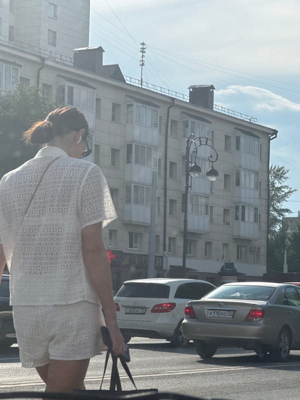 Midday street life across a busy stretch in Tyumen, Russia