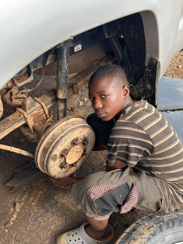 Roadside tire and brake repair on a pickup truck in Nigeria