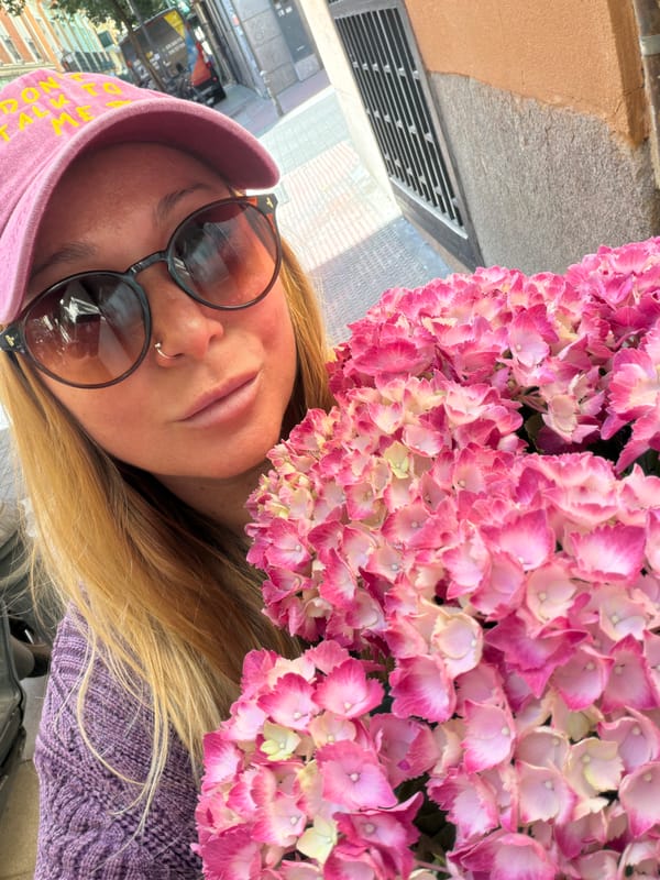 Person in Pink Hat Photographed with Flowers in Madrid