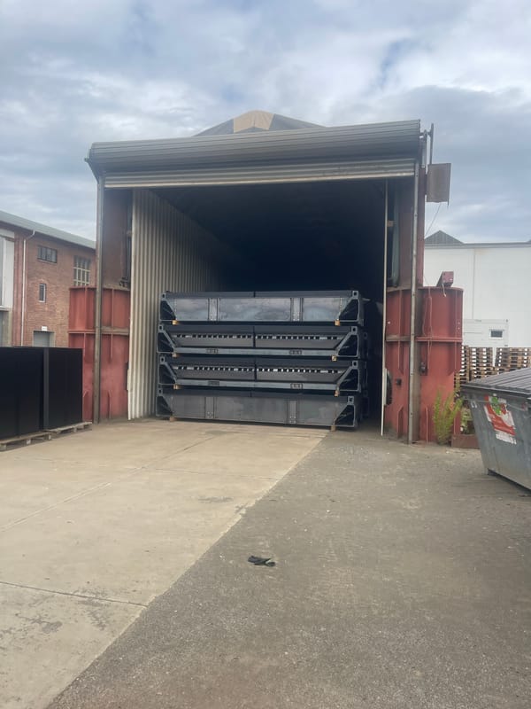 Inside a heavy industrial yard: forklifts, SPMTs, and large equipment