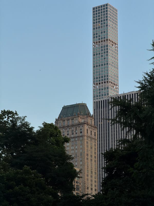 432 Park Avenue towers above green trees in midtown Manhattan