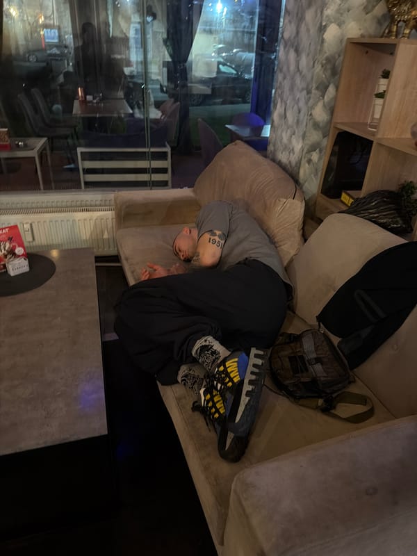 Man relaxes on sofa at midnight in Pernik, Bulgaria