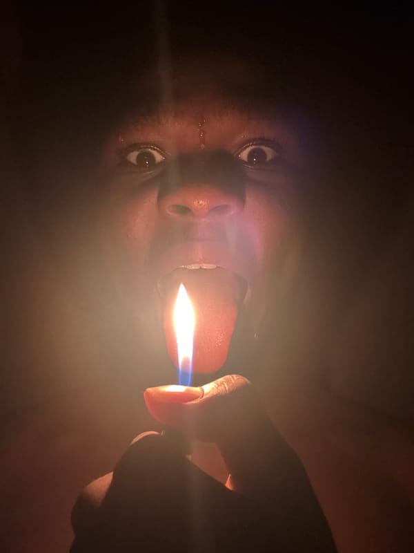 Person photographed with lighter, hands obscuring face in Onitsha