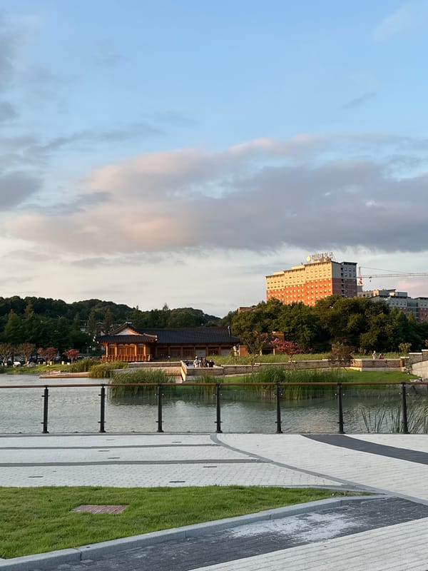 Lotus pond at dusk, Jeonju — blooms, boardwalk, traditional architecture