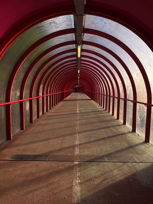 Red-framed pedestrian tunnel documented in Glasgow morning hours