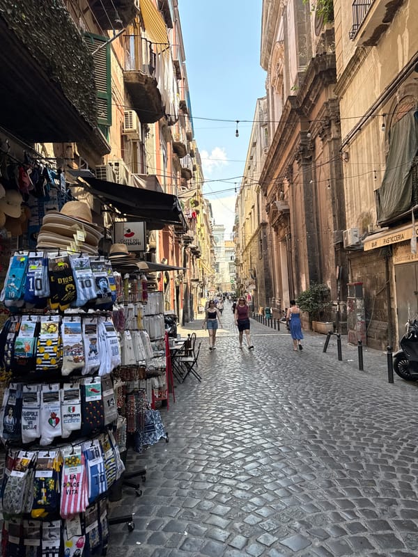 Sunny morning stroll through a narrow Naples cobblestone street