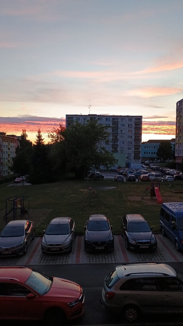 Sunset over Sokolov rooftops, framed by windowsill plants