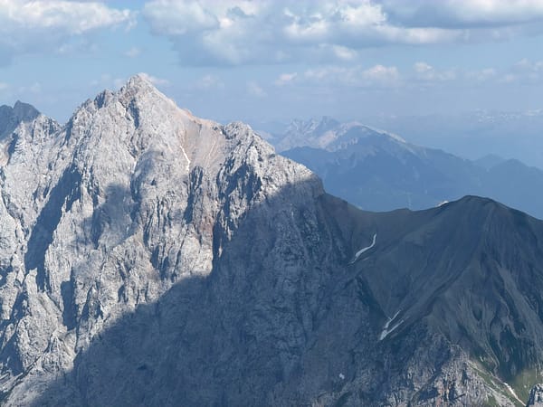 Rocky Zugspitze slopes with a parked snow groomer, late June