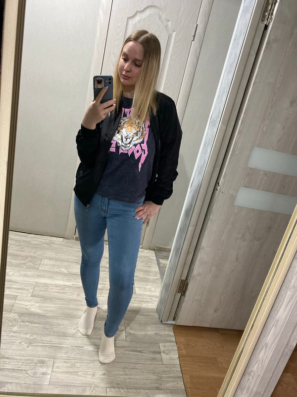 Woman takes mirror selfies in tiger graphic shirt