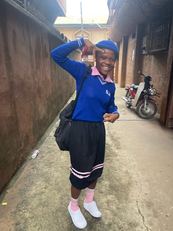 School uniforms and a wooden gate in Fegge, Nigeria