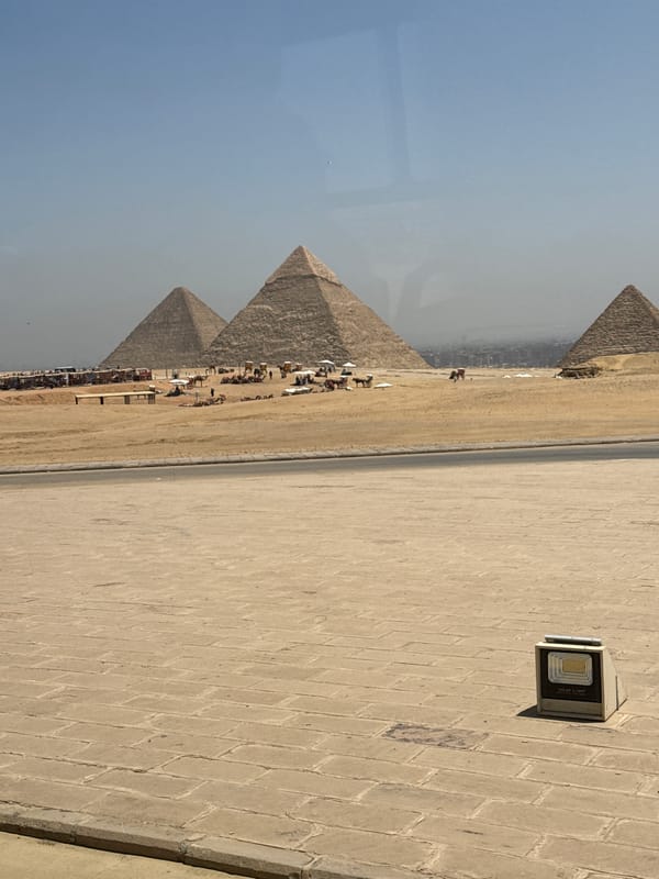 Tourists photograph Giza pyramids on hazy morning