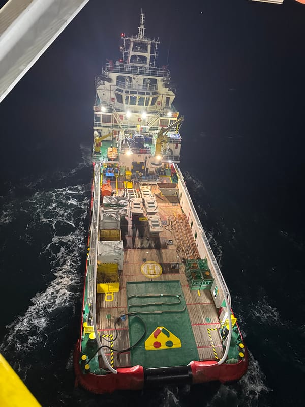 Illuminated cargo ship observed at night off Italian coast