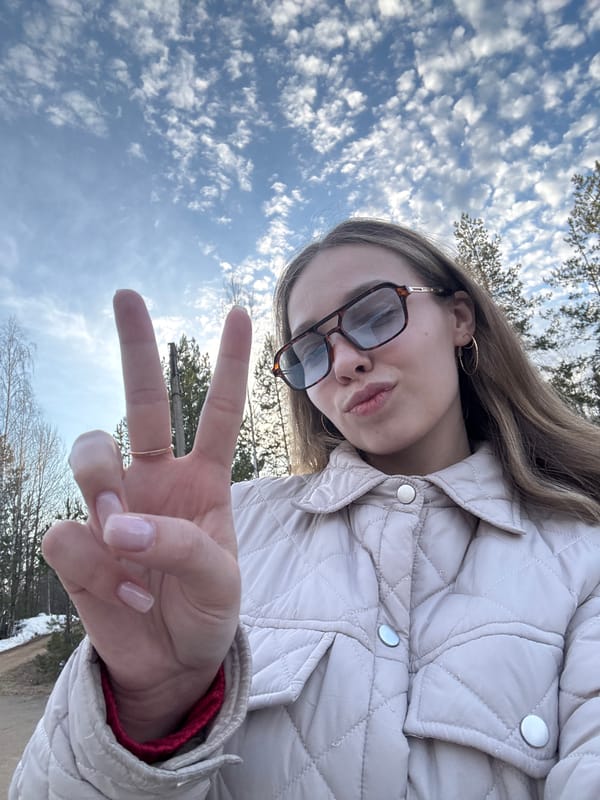 Woman takes peace sign selfie outdoors in Chaykovsky