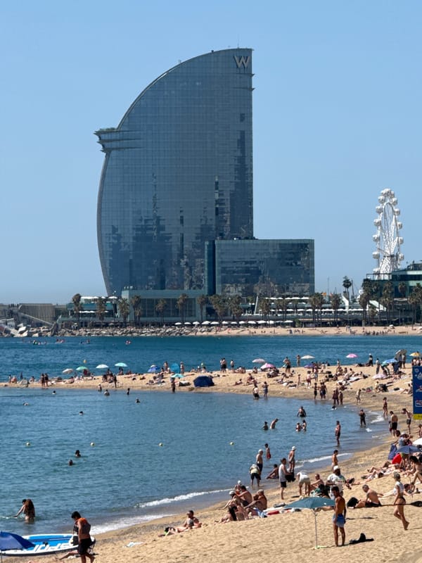 Morning beach activities observed at Barcelona's Barceloneta under sunny skies