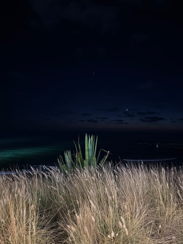 Bat Yam beachfront at night, crescent moon over calm sea