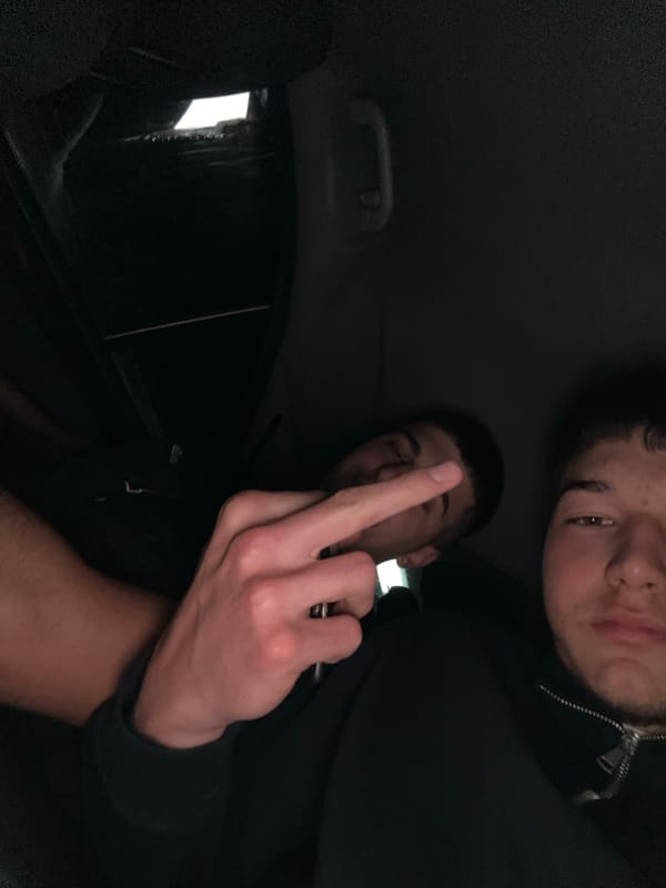 Two men in vehicle, one making obscene gesture, Zlatograd