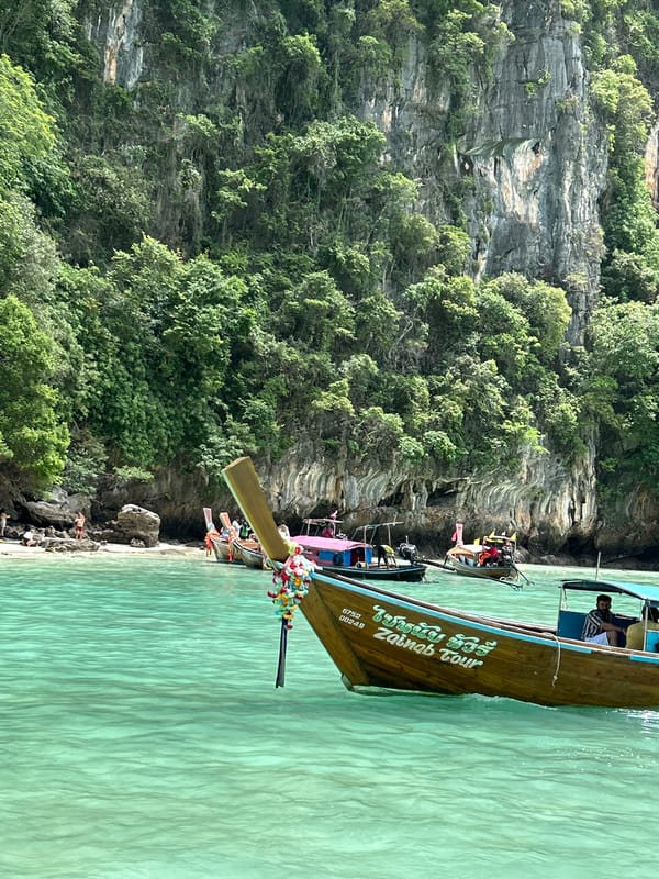 Longtail boats weaving through Ao Nang's limestone cliff waters