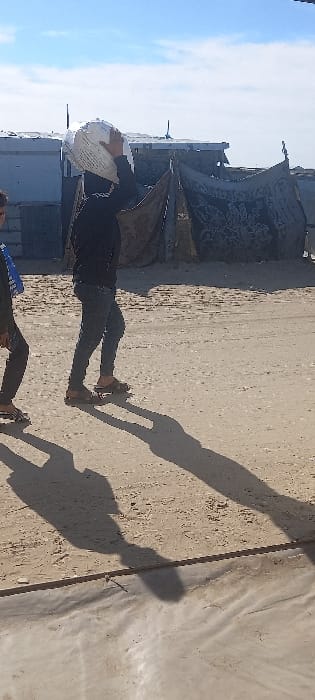 Residents traverse sandy streets in Khan Yunis displacement area