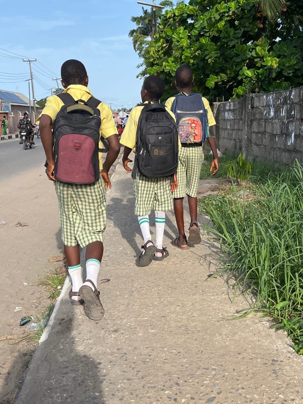 School children in uniforms walk streets of Badagry Nigeria