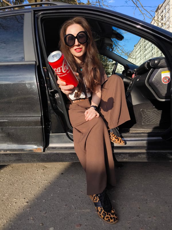 Woman poses with Coca-Cola can in Riga park photoshoot