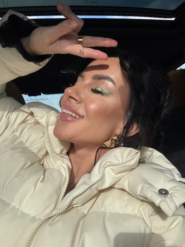 Person photographed smiling and waving inside car in Krasnoyarsk