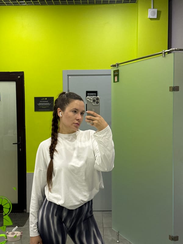 Woman takes selfie against green wall in Vniissok, Russia