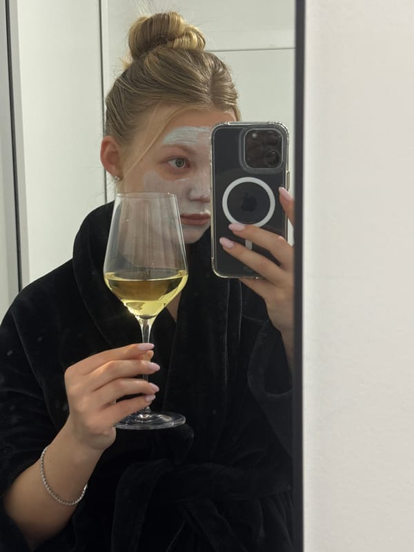 Person documents skincare routine with wine, selfie in Ariel