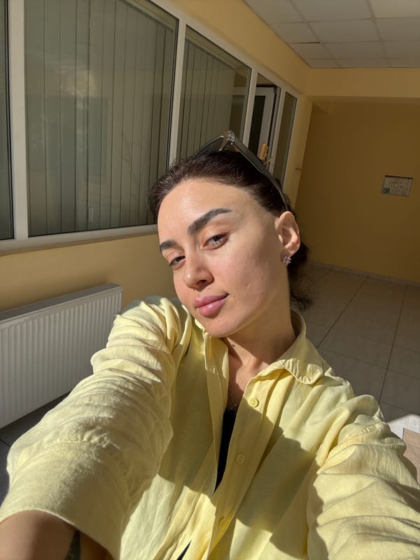 Woman poses for selfies in yellow shirt, Tbilisi morning