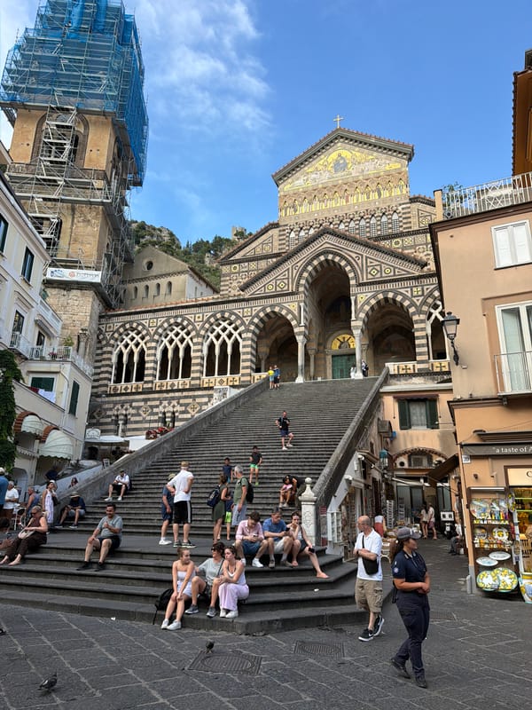 Tourists rest on Amalfi Cathedral steps with police present
