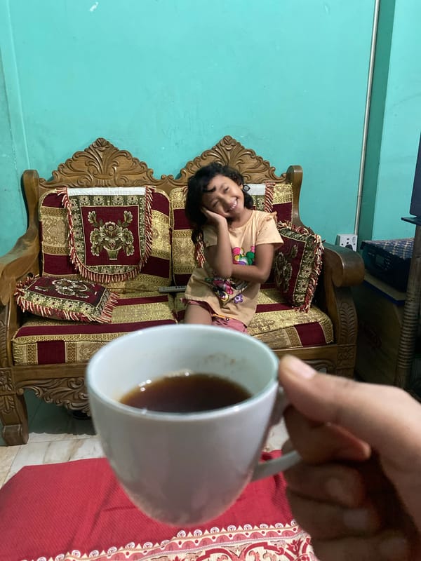 Child draws with henna-decorated hands in Dhaka home