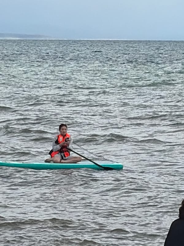 Paddleboarding session on a grey lake with mountain scenery