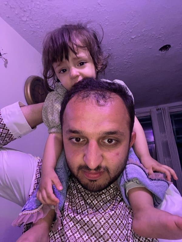 Father carries child on shoulders in Kandahar