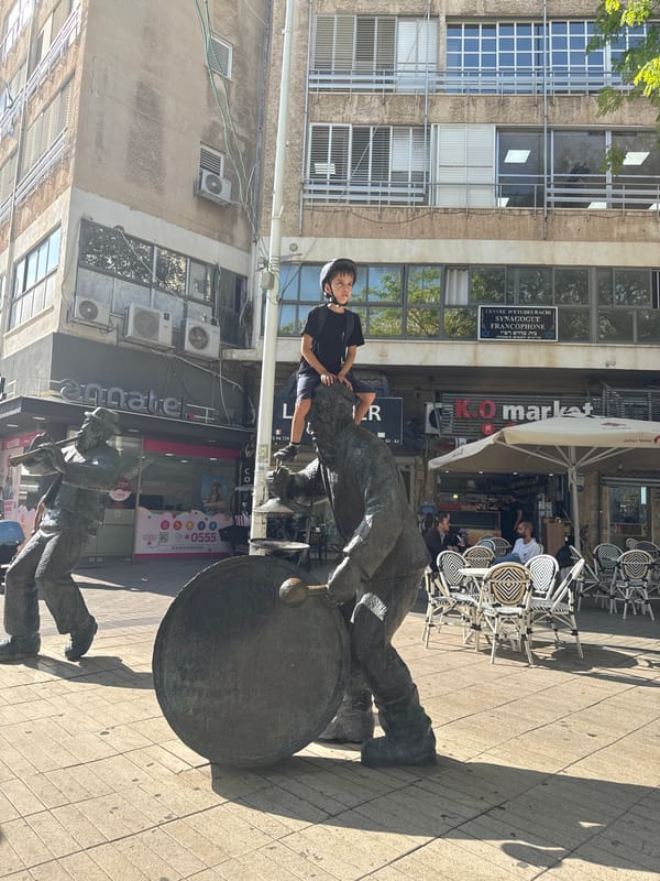 Child plays among bronze musician statues in Netanya square