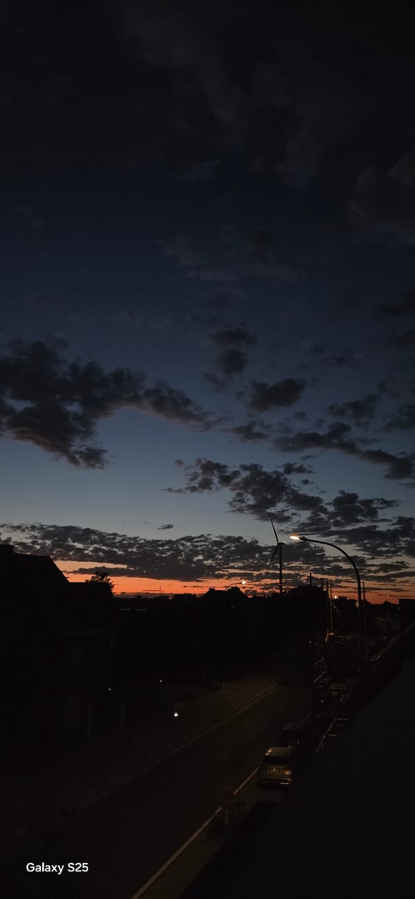 Sunset to twilight: wind turbine and suburban skyline at dusk