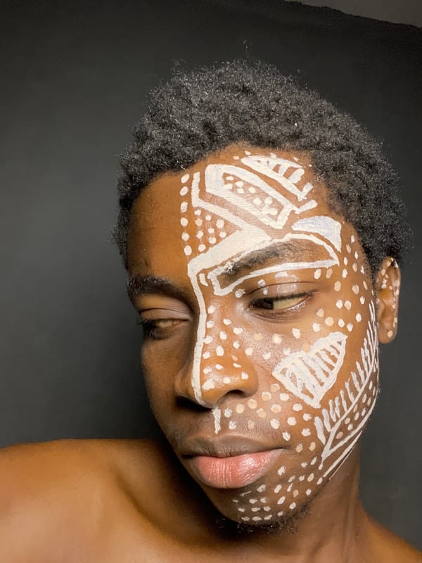 Person displays traditional white tribal face paint in Nkpor