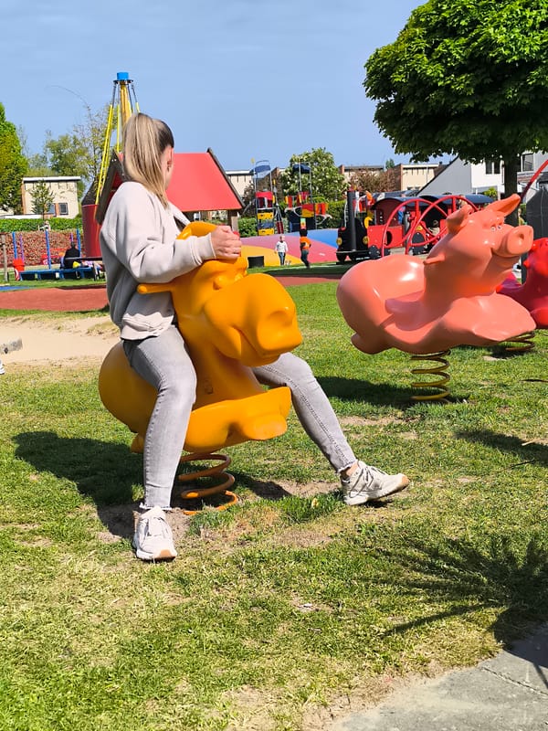 Woman rides playground spring rider in Alkmaar