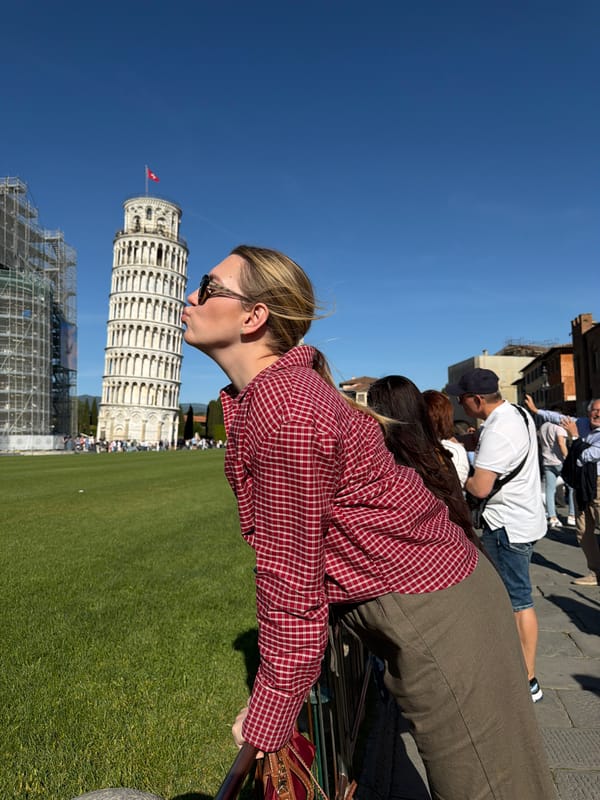 Tourist poses with Leaning Tower during scaffolding work