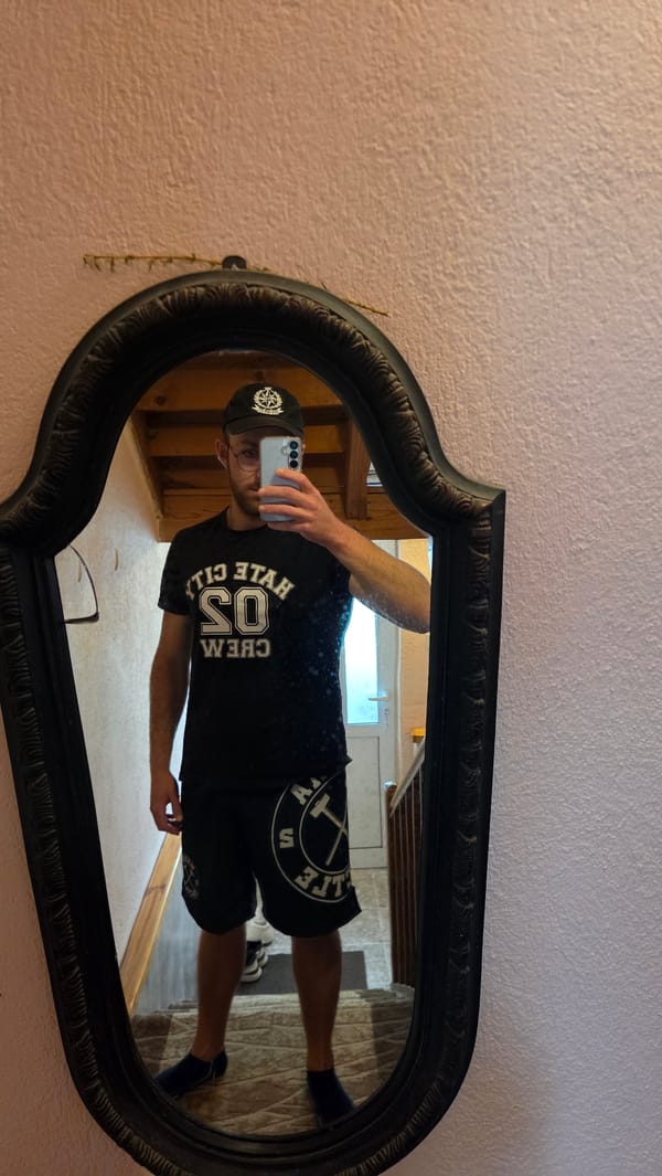 Man takes mirror selfies at home wearing crew t-shirt